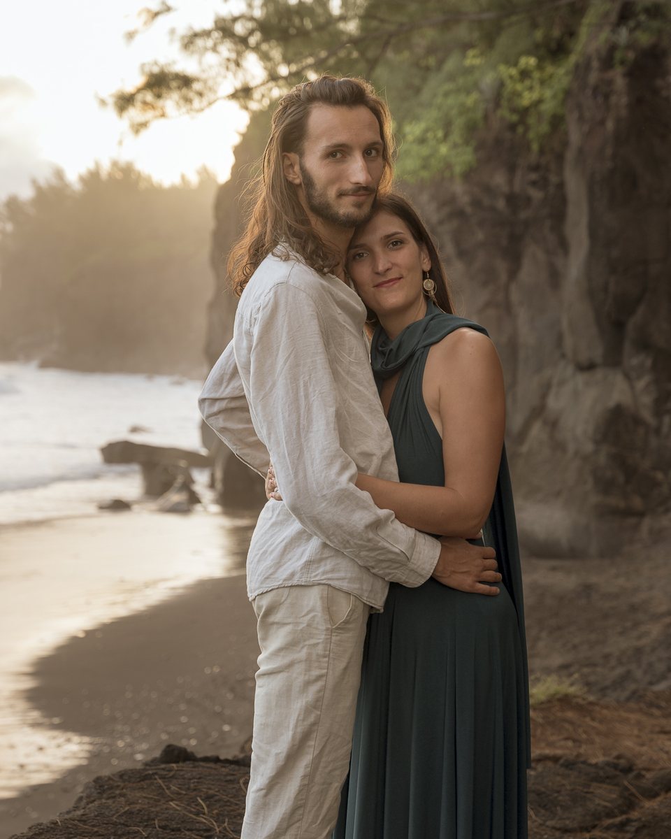 Aurélie et Jonathan, enlacés et souriants, au bord d'une rivière dans la lumière dorée du soir